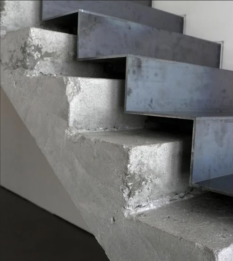 Folded steel treads on a concrete stair